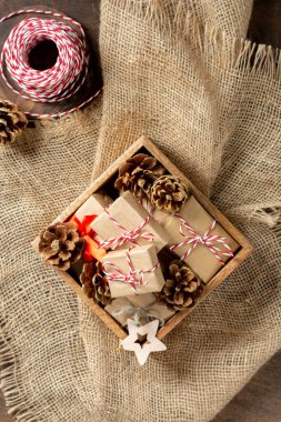 Çevre dostu el sanatları kağıdında noel hediyesi kutuları. Tahta bir masanın üzerindeki tahta kutuda hediyeler. Çevre dostu hediye paketi