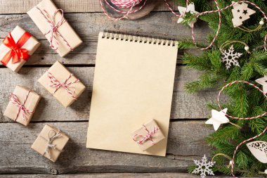 Noel ya da yeni yıl arkaplanı boş bir not defteri, ladin dalları ve Noel çevre dostu ahşap süslemelerle dolu. Kontrol listesi ya da Noel Baba 'ya mektup. Noel tebrik kartı. Kopyalama alanı