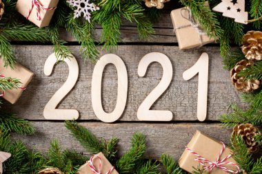 Mutlu yıllar 2021. 2021 numara ahşap zemin üzerinde ahşaptan yapılmıştır. Köknar dallı Noel arkaplanı