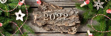 Mutlu yıllar 2022. 2022 numaralı oda ahşaptan yapılmıştır. Noel arkaplanı köknar dallarıyla dolu. ECO dekorasyonları