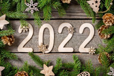 Mutlu yıllar 2022. 2022 numaralı oda ahşaptan yapılmıştır. Noel arkaplanı köknar dallarıyla dolu. ECO dekorasyonları