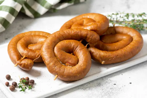 Salsichas Fumadas Espiral Uma Tábua Serviço Uma Mesa Cinza Clara — Fotografia de Stock