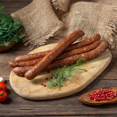 Kahverengi ahşap bir masada servis tahtasında geleneksel domuz sosisi. Tirol sosisi