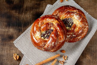 Ahşap bir masada reçelli çörekler. Kiraz reçelli turta ve badem ezmesi. Kaba lezzetli hamur işleri.