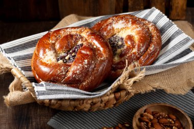 Ahşap bir masada reçelli çörekler. Kiraz reçelli turta ve badem ezmesi. Kaba lezzetli hamur işleri.