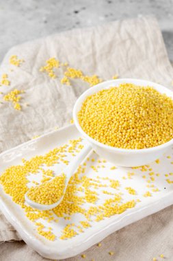 Millet. Millet açık gri mutfak masasında beyaz bir kasede