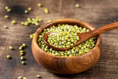 Mung. Kahverengi ahşap bir masada bir kasede yeşil fasulye. Sağlıklı bir diyet için baklagil bitkisi