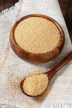 Amaranth. Kahverengi ahşap mutfak masasında ahşap bir kasede Amaranth tohumları