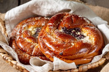Ahşap bir masada reçelli çörekler. Kiraz reçelli turta ve badem ezmesi. Kaba lezzetli hamur işleri.