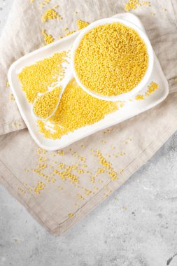 Millet. Millet açık gri mutfak masasında beyaz bir kasede