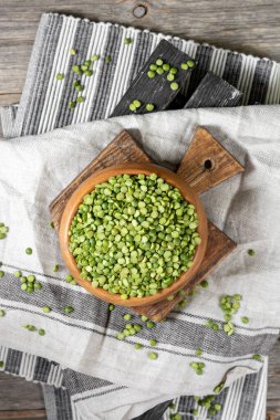 Yeşil bezelyeler. Ahşap bir masada tahta bir kasede kuru yeşil bezelyeler. Organik Doğal Vejetaryen Ürünleri