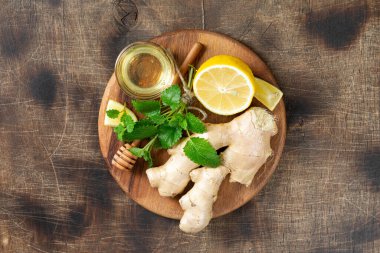  Limonlu, ballı ve naneli zencefilli çay. Limon, zencefil, bal ve limon merhemi masada. Bağışıklığı arttırmak için sağlıklı yiyecekler. Zencefilli kurabiye için bal ve nane. Üst görünüm 