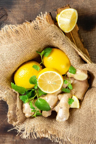 Ingredients for ginger tea with lemon and mint. Lemon, ginger,  and lemon balm on the table. Healthy food to boost immunity. Ingredients for ginger cookies with  and mint