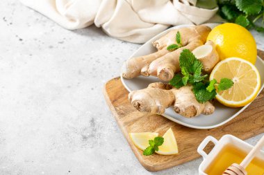 Limonlu, ballı ve naneli zencefilli çay. Limon, zencefil, bal ve limon merhemi masada. Bağışıklığı arttırmak için sağlıklı yiyecekler. Zencefilli kurabiyeler için bal ve nane