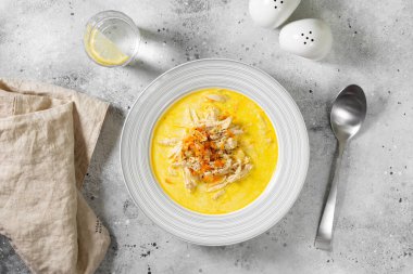 Kremalı et suyunda tavuk göğsü. Sebzeli ve kremalı tavuk. Açık gri mutfak masasında bir kasede tavuk çorbası. Üst görünüm