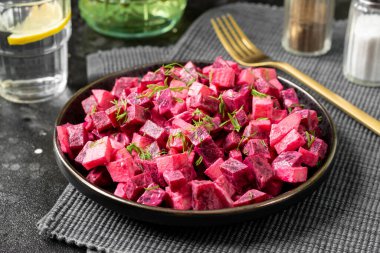 Geleneksel İskandinav salatası pancar kökü ve elmalı mayonez, ekşi krema ve balzamik sirke. Siyah bir masada siyah bir tabakta elmalı pancar turşusu. Koyu renk