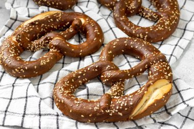 Alman krakeri. Açık gri mutfak masasında susamlı krakerler. Brezel masada.