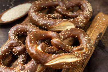 Alman krakeri. Kahverengi ahşap mutfak masasında susamlı krakerler.