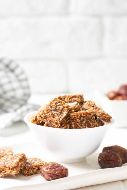 Hindistan cevizli kurabiyeler, hurma ağaçları ve yakın plan beyaz bir kasede havuçlar. Sağlıklı atıştırmalık konsepti şekersiz.