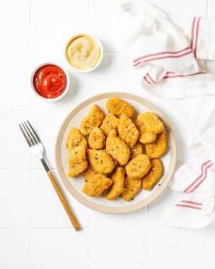 Bir tabakta tavuk nugget ketçap ve arka planda peynir sosu. Fast food üst görünümü