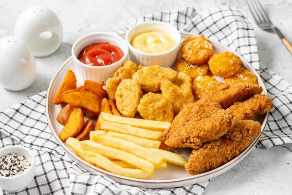 Kipnuggets Strips Frietjes Gebakken Aardappelen Ketchup Kaassaus Een Lichte Ondergrond — Stockfoto