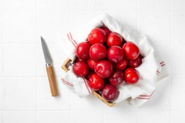 Beyaz masa manzaralı bir sepette Çin ya da Kore kırmızı eriği. Yaz hasadı