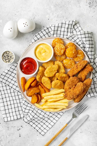 Kipnuggets Strips Frietjes Gebakken Aardappelen Ketchup Kaassaus Een Lichte Ondergrond — Stockfoto