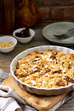 Gri ahşap mutfak arka planında, içinde süt ve acı çikolata bulunan ev yapımı kurabiye turtası. Lezzetli köylü tatlıları.