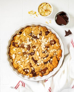 Ev yapımı kurabiye turtası, sütlü ve acı çikolatalı. Bir fotokopi alanının arka planında beyaz bir yemek kabında. Lezzetli köylü tatlıları.