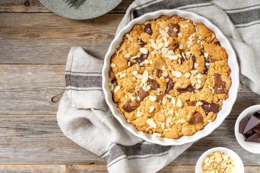 Ev yapımı, sütlü ve acı çikolatalı kurabiye. Gri ahşap mutfak arka plan manzaralı bir kabın içinde. Kopyalama uzayından. Lezzetli köylü tatlıları.