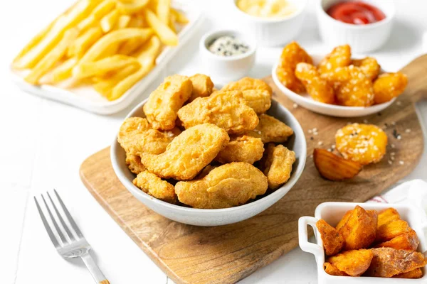 Kipnuggets Strips Frietjes Gebakken Aardappelen Ketchup Kaassaus Een Lichte Ondergrond — Stockfoto