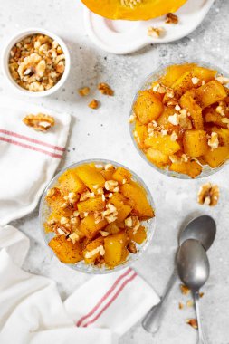 Geleneksel Türk yemeği, açık gri arka planda cam bir kasede pişmiş kabak tatlisi. Lezzetli sağlıklı tatlı üst görünümü