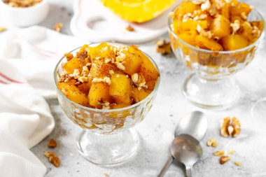 Geleneksel Türk yemeği, açık gri arka planda cam bir kasede pişmiş kabak tatlisi. Lezzetli, sağlıklı bir tatlı. Yakın plan.