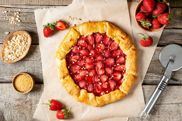 Fransız galeti ya da çilekli turta ve arkaplan manzaralı fırın kağıdı üzerine badem. Yaz ev yapımı tatlı hamur işleri