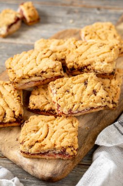 Açık gri ahşap mutfak masasının üzerinde vişne reçelli kurabiyeler. Lezzetli ev yapımı tatlı hamur işleri