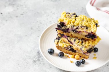 Açık gri ahşap mutfak masasında beyaz tabakta yaban mersinli kurabiyeler. Lezzetli ev yapımı tatlı hamur işleri