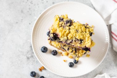 Açık gri ahşap mutfak masasında beyaz tabakta yaban mersinli kurabiyeler. Lezzetli ev yapımı tatlı hamur işleri
