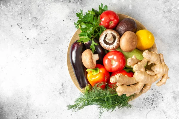 Fasting mimicking diet food. FMD to improve health and lose weight. A mix of vegetables, nuts, herbs, seeds and mushrooms on a light gray background