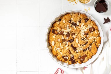 Ev yapımı kurabiye turtası, sütlü ve acı çikolatalı. Bir fotokopi alanının arka planında beyaz bir yemek kabında. Lezzetli köylü tatlıları.