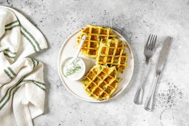 Beyaz tabakta ev yapımı kabak waffle 'lar açık gri bir mutfak arka planında kopyalanmış bir mekandan üst görünüm