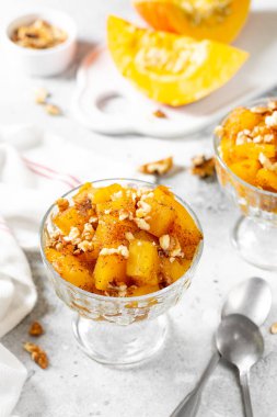 Geleneksel Türk yemeği, açık gri arka planda cam bir kasede pişmiş kabak tatlisi. Lezzetli, sağlıklı bir tatlı. Yakın plan.