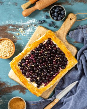 Mutfak masasındaki servis masasında süzme peynirli ve yaban mersinli puf böreği.