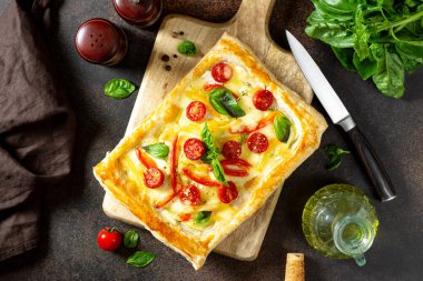 Karışık sebzeli puf böreği ve servis masasının üstünde mozzarella peyniri. Domatesli lezzetli hamur işleri, kabak, tatlı biber, baharat ve fesleğen.