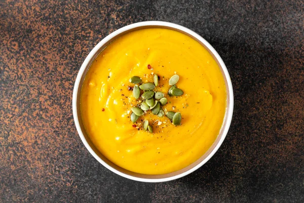 Kabak kremalı çorba. Tohumları koyu arkaplanlı. Geleneksel sonbahar vejetaryen yemeği.