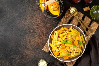 Napoli usulü makarna, kabaklı, seramik tabakta, arka planda koyu renk mutfak manzaralı. Geleneksel İtalyan mutfağı