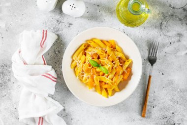 Açık gri arka plan manzaralı ve fotokopi alanı olan seramik tabakta kabaklı Napoli makarna penne rigate. Geleneksel İtalyan mutfağı