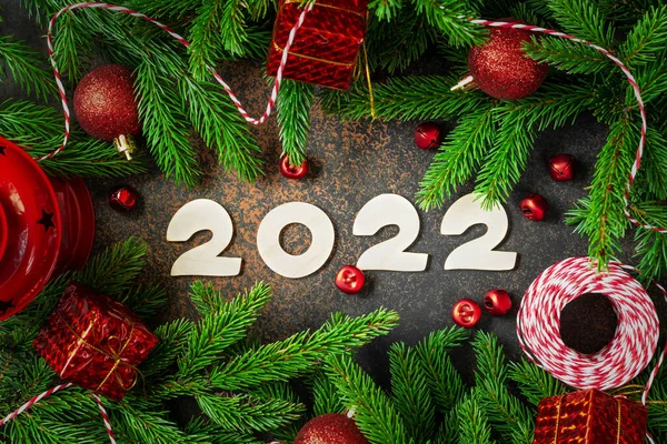 新年快乐 圣诞树树枝上的红色圣诞装饰品 节日背景 木制编号2022 顶部视图 — 图库照片