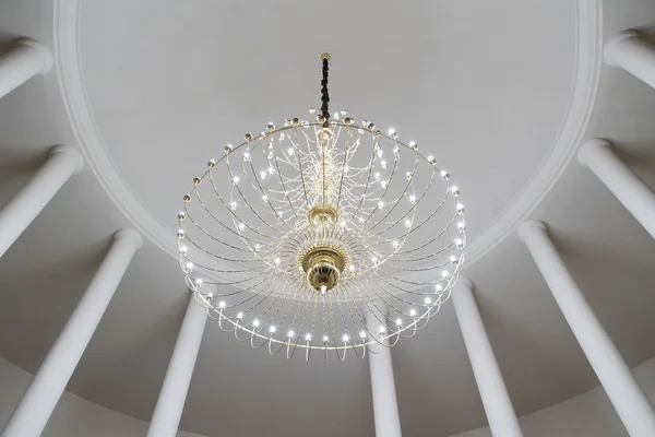 Sala rotonda con colonne e lampadario sul soffitto Foto Stock Royalty Free
