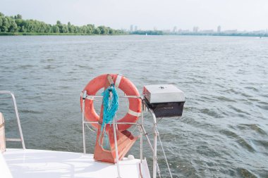 Yatta cankurtaran şamandırası var, yatın arkasında. Güneşli bir gün, denizde..