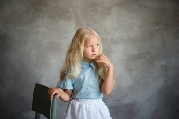 Bela Menina Loira Fica Perto Uma Cadeira Contra Fundo Uma — Fotografia de Stock